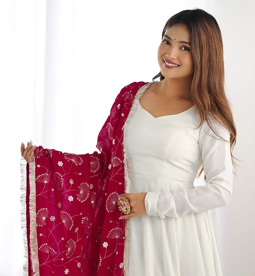 Elegant plain white georgette anarkali gown with long sleeves, styled with a fuchsia dupatta featuring all-over gold floral print and a tassel border.