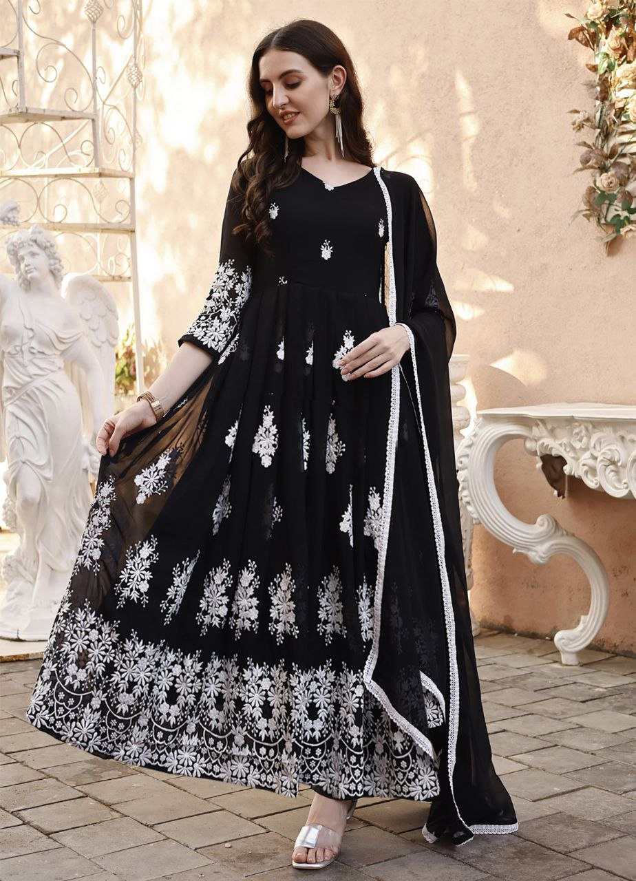 Woman wearing black georgette anarkali suit with intricate white floral embroidery and matching dupatta.