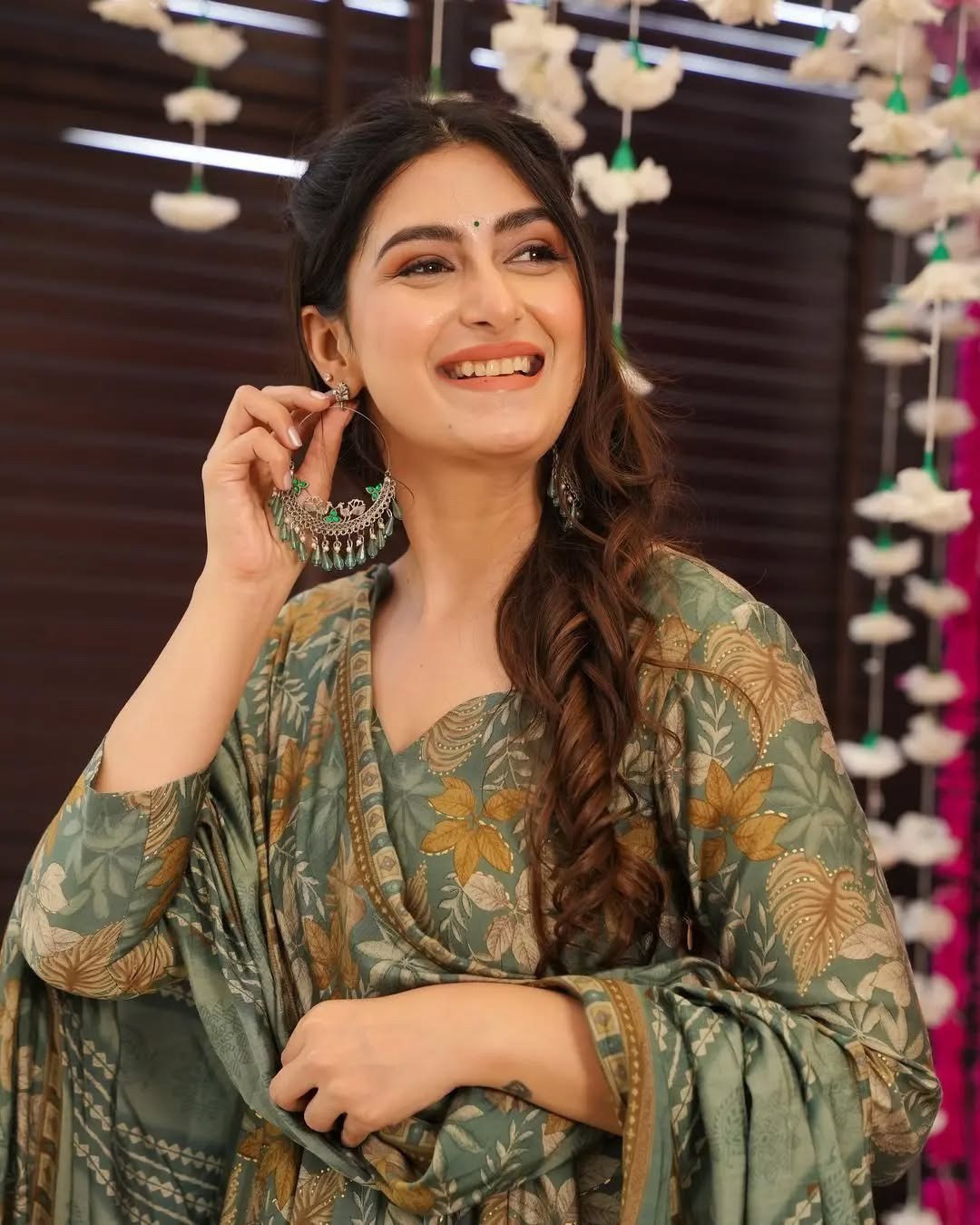 Full length view of a block print style green anarkali with all-over floral pattern, paired with printed palazzo.
