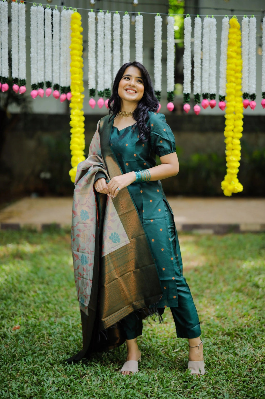 Bottle green kurta with subtle dot detailing, paired with palazzo pants and a richly woven Banarasi silk dupatta.