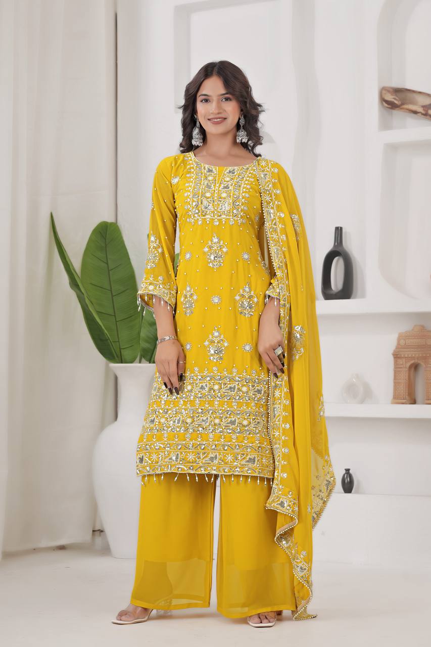 Woman wearing a bright yellow georgette kurta palazzo set with heavy silver embroidery and mirror work on the kurta, sleeves, and dupatta, perfect for Haldi functions.