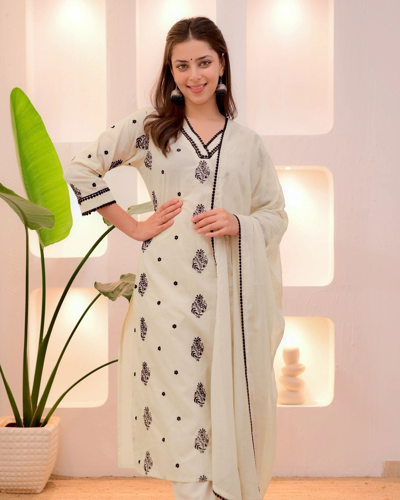 Model in a casual and festive off-white kurta set with black detailing, comfortable for daily wear or small events.