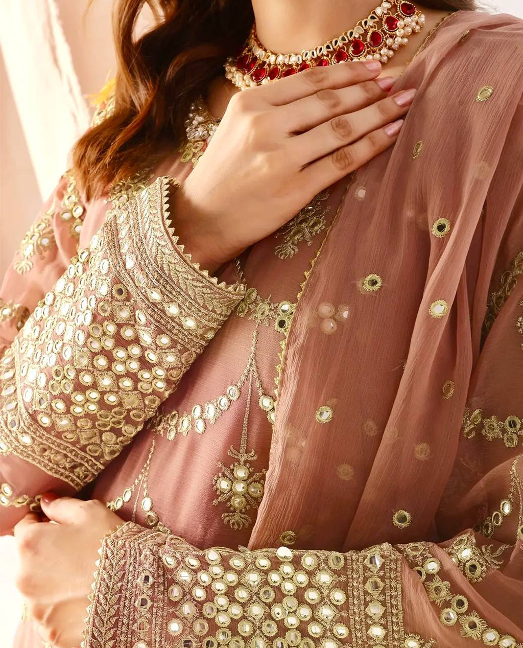 Contemporary dusty pink sharara set for women, with a heavily embroidered kurta, tiered sharara, and a matching sheer organza dupatta with gold borders.