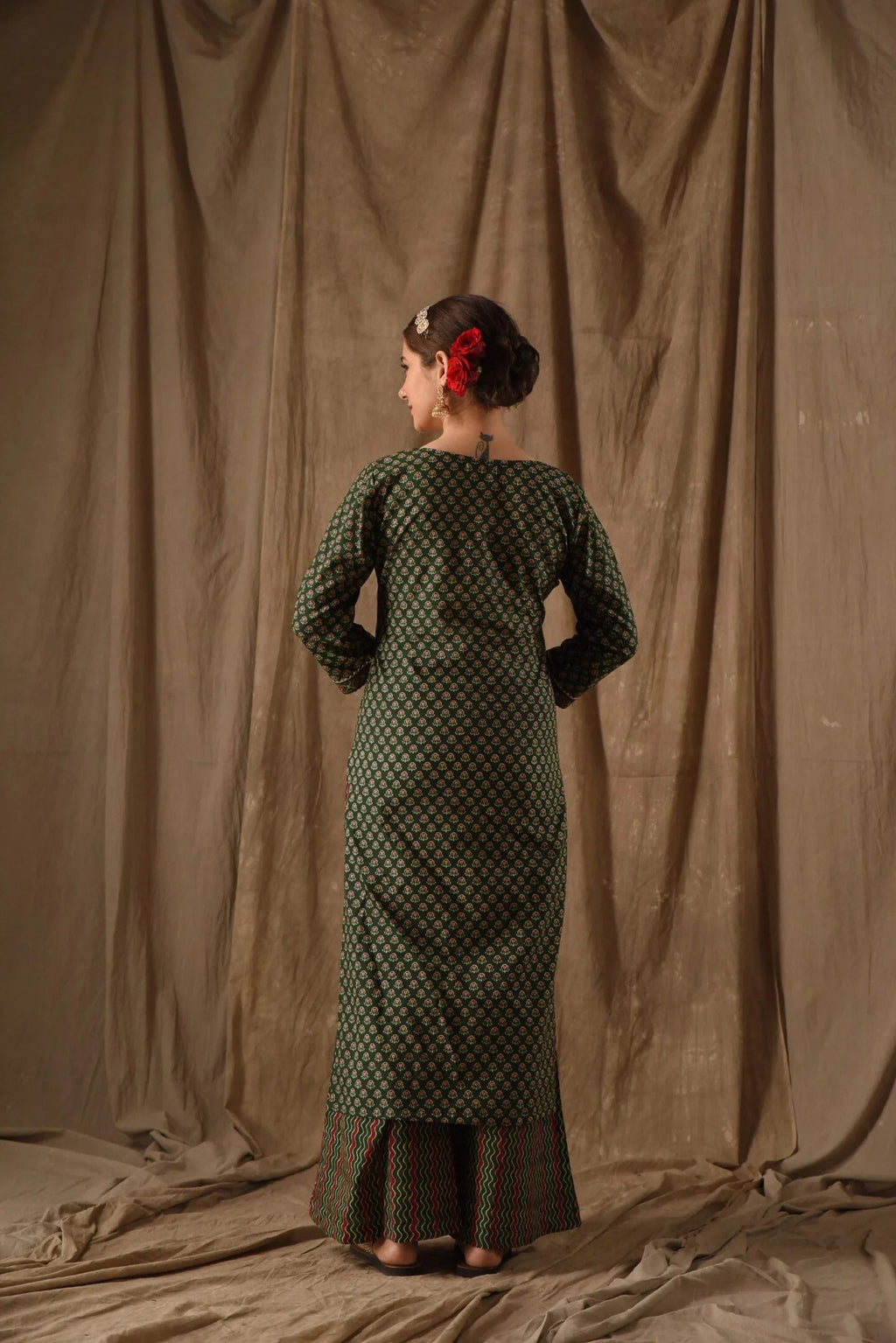 Full length view of a comfortable daily wear dark green anarkali kurta with all-over prints.