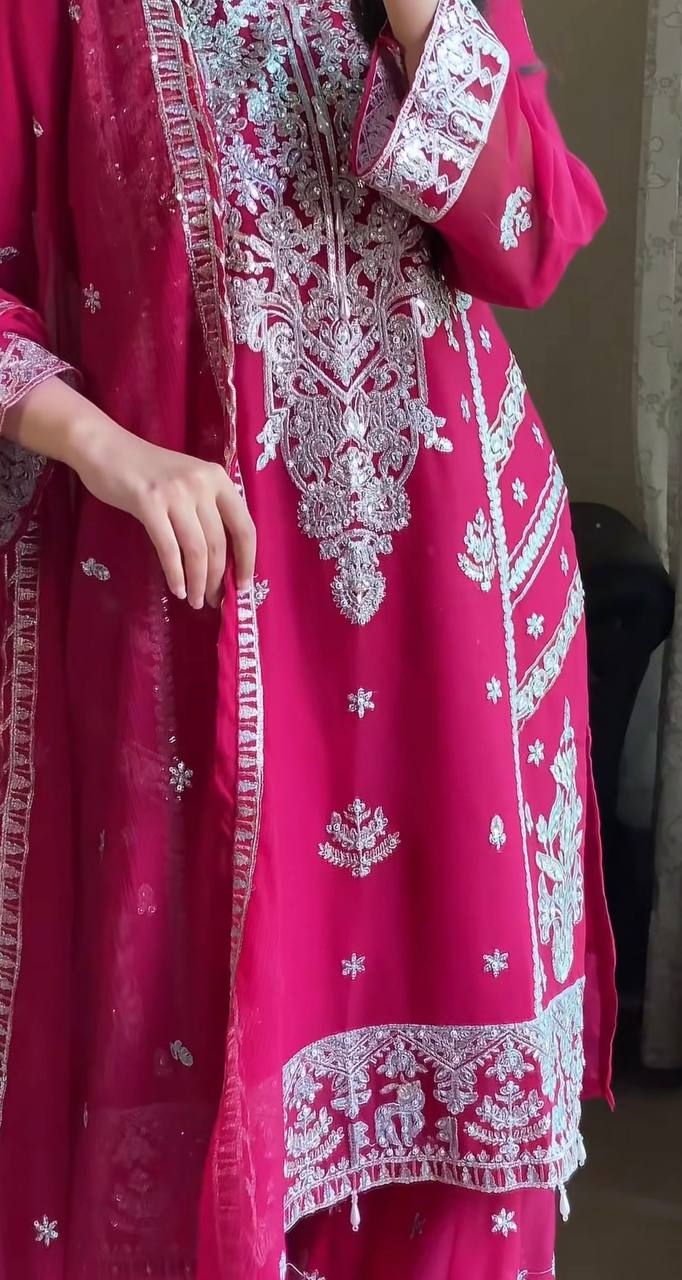 Designer fuchsia pink party wear sharara set for women, featuring a heavily embellished kurta with intricate silver work and a voluminous tiered sharara.