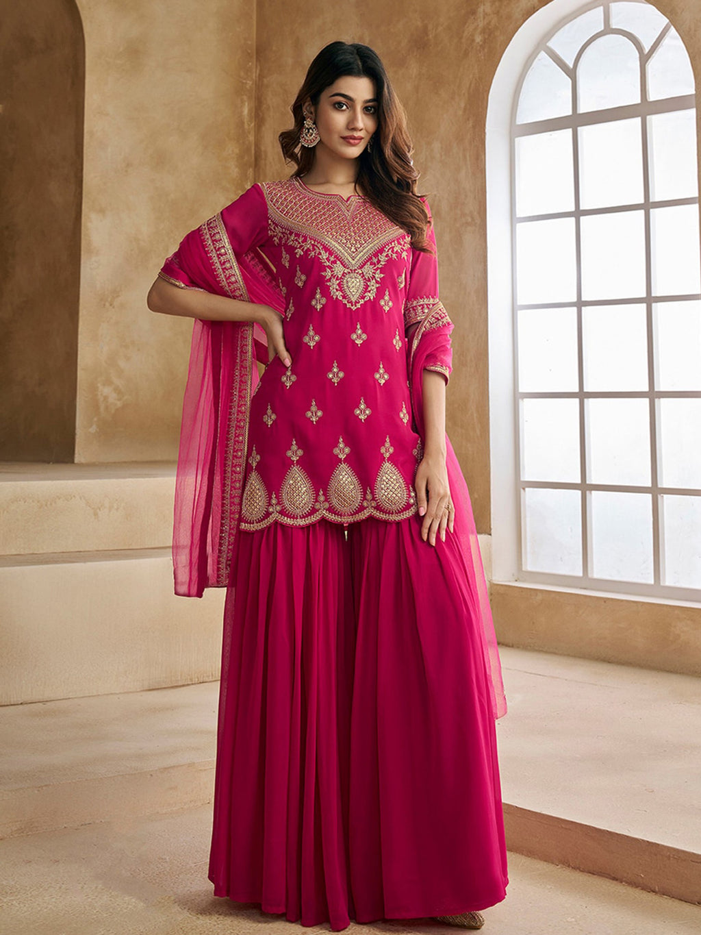 Designer fuchsia pink sharara gharara set for women, featuring a georgette kurta with heavy embroidery and a voluminous flared sharara.
