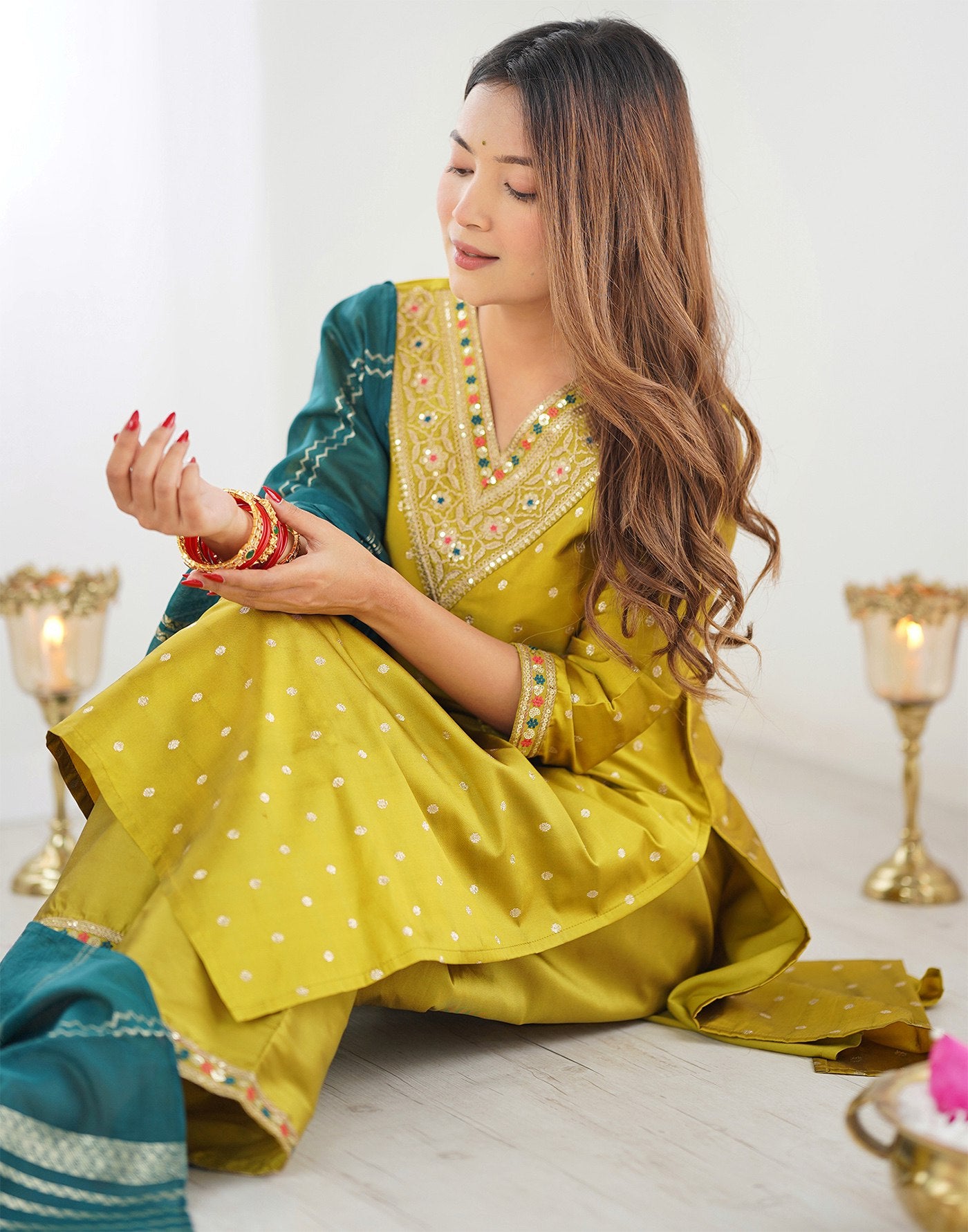 Designer mustard gold Punjabi suit with intricate V-neck embroidery, dot motifs, and a striking teal woven dupatta.
