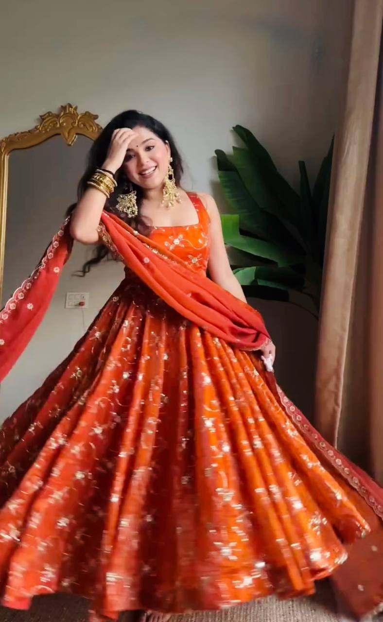 Designer rust orange party wear anarkali dress for women, featuring all-over gold work, a full flare, and a matching dupatta, ideal for festive celebrations.