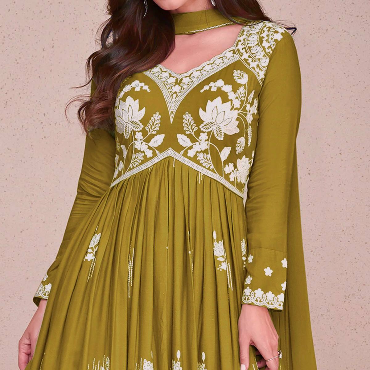 Designer sage green flared Anarkali suit for women, featuring a V-neck kurta with extensive white thread work and matching embroidered palazzo pants, perfect for festive wear.