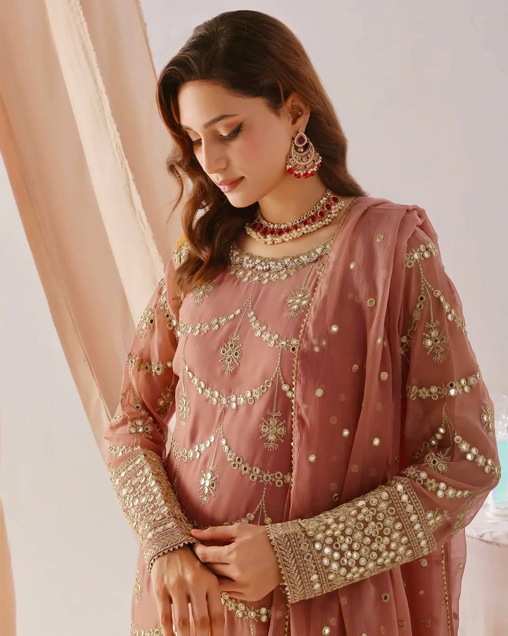 esigner salmon pink party wear gharara set for women, featuring a heavily embellished kurta with mirror work and a voluminous tiered sharara.