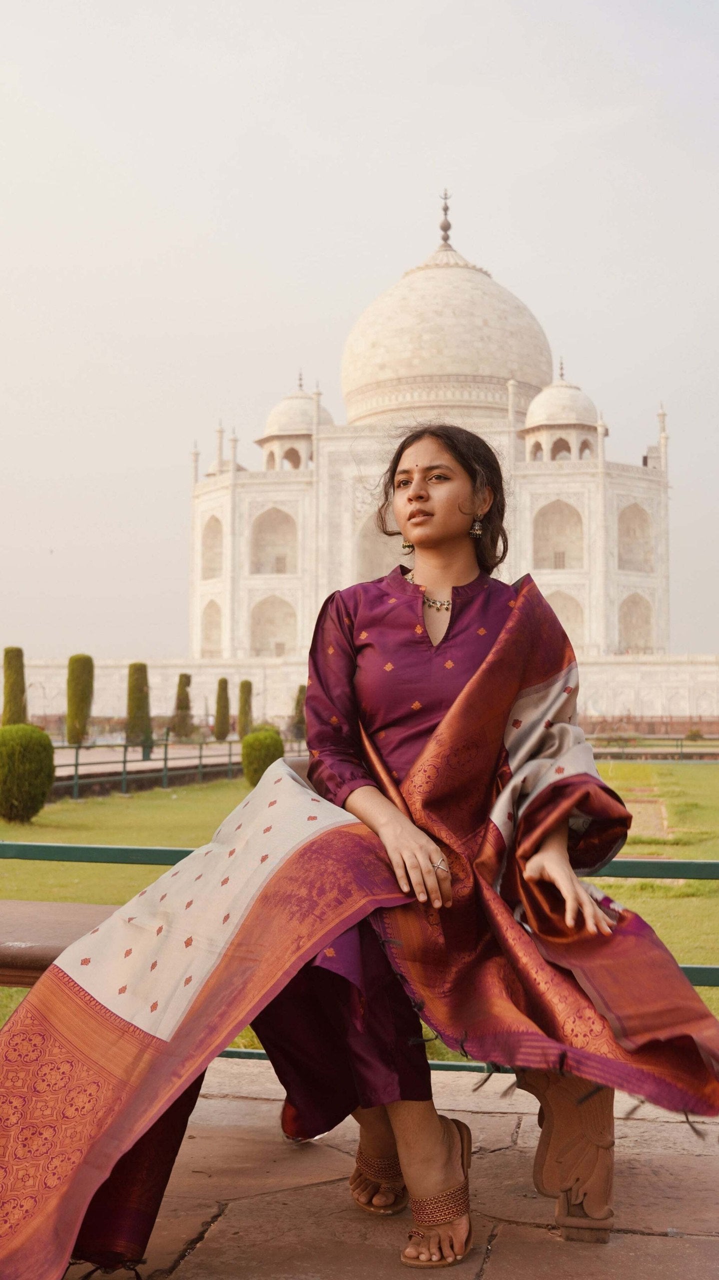 Designer wine purple ethnic suit featuring a silk blend kurta with elegant motifs, straight pants, and a contrasting woven dupatta.
