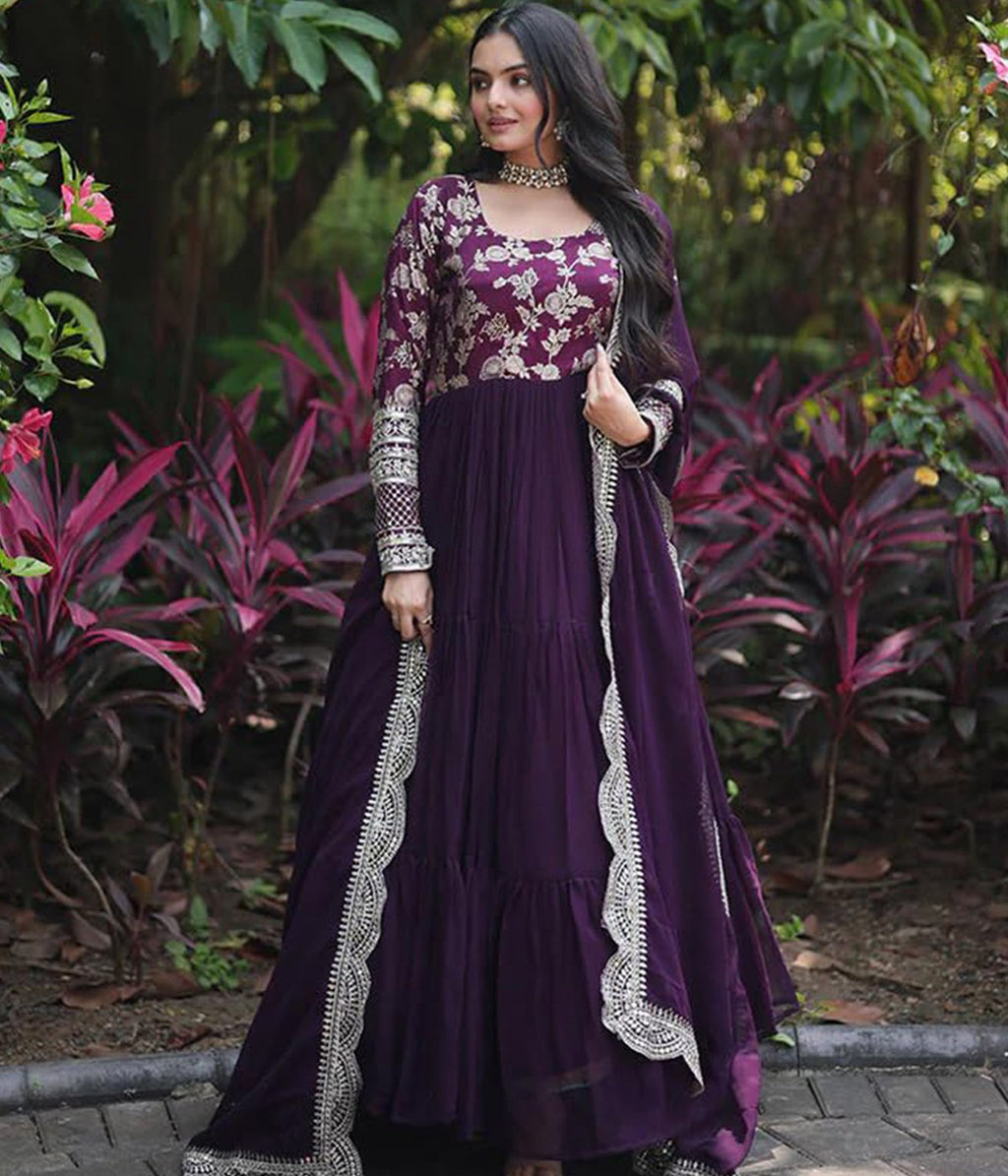 Embroidered violet anarkali suit with a tiered design, intricate gold work on the bodice, and a coordinating scalloped-edge dupatta.