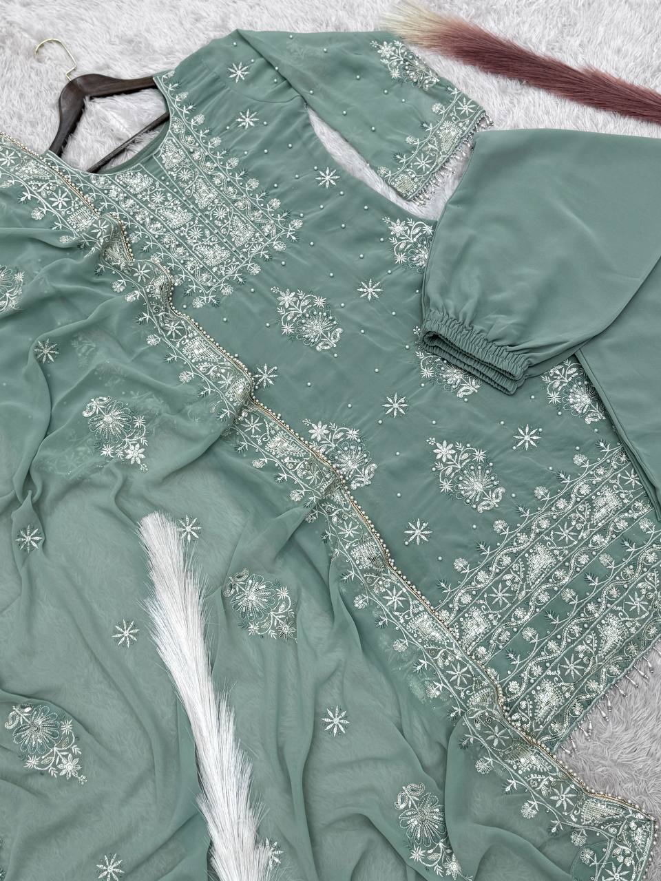 Model in a festive mint green Chikankari style embroidered kurta set with broad palazzo pants and a matching dupatta, ideal for daytime events.