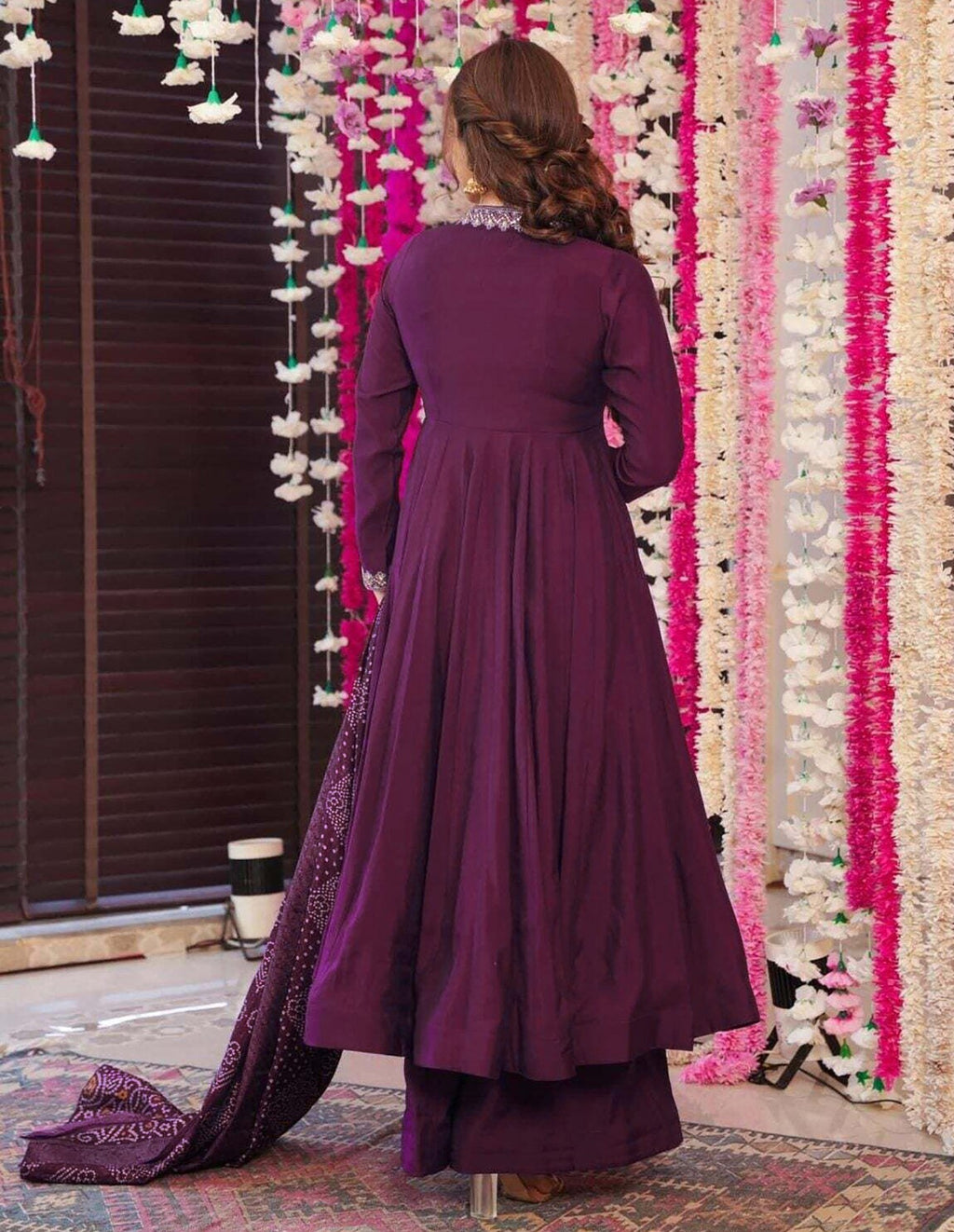 Model in a festive plum anarkali dress with subtle embroidery on the neckline, matched with a vibrant tie-dye Bandhani dupatta.
