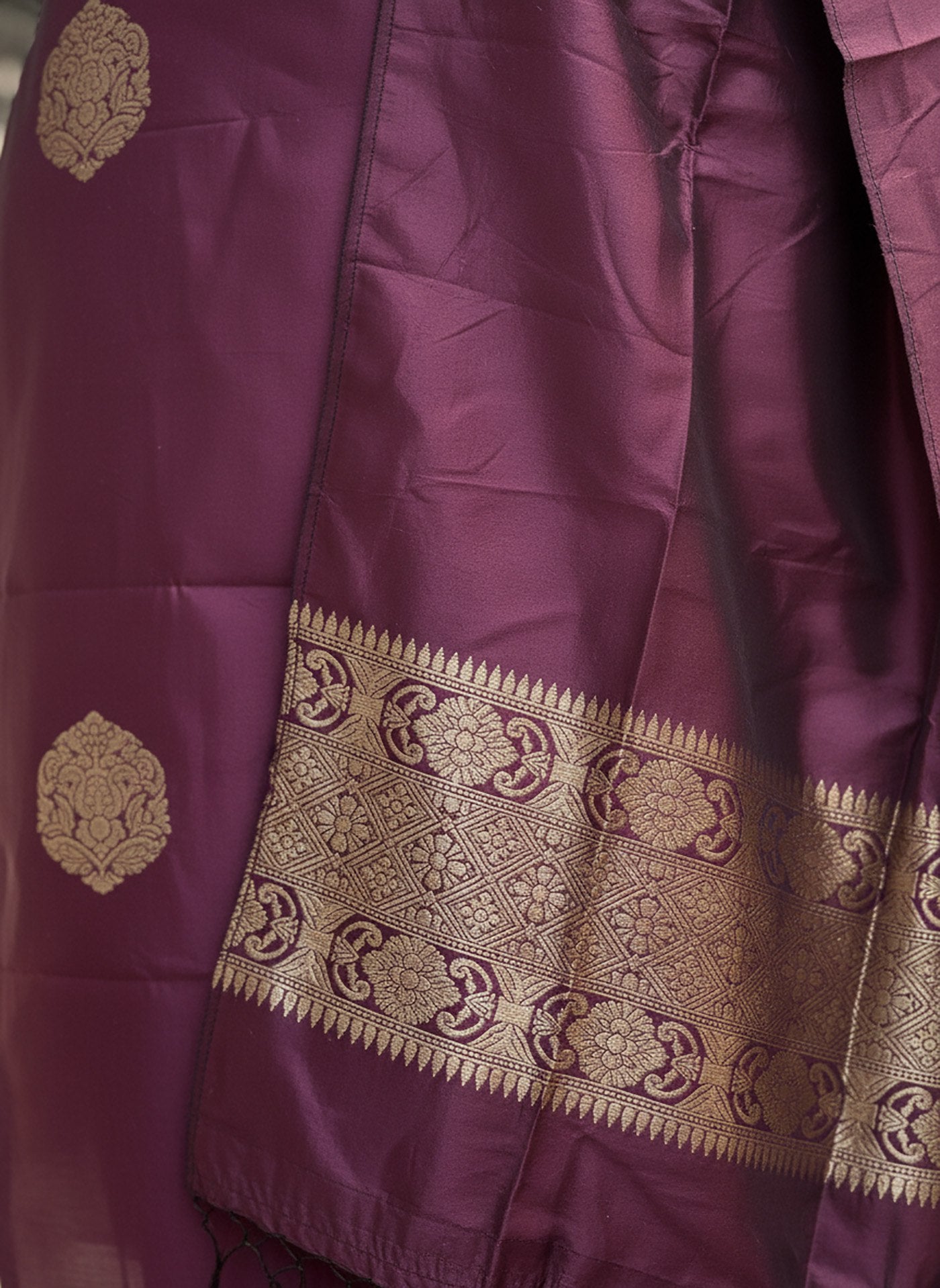 Model in a festive plum kurta set with gold woven motifs on the kurta and a richly bordered dupatta, perfect for celebrations.
