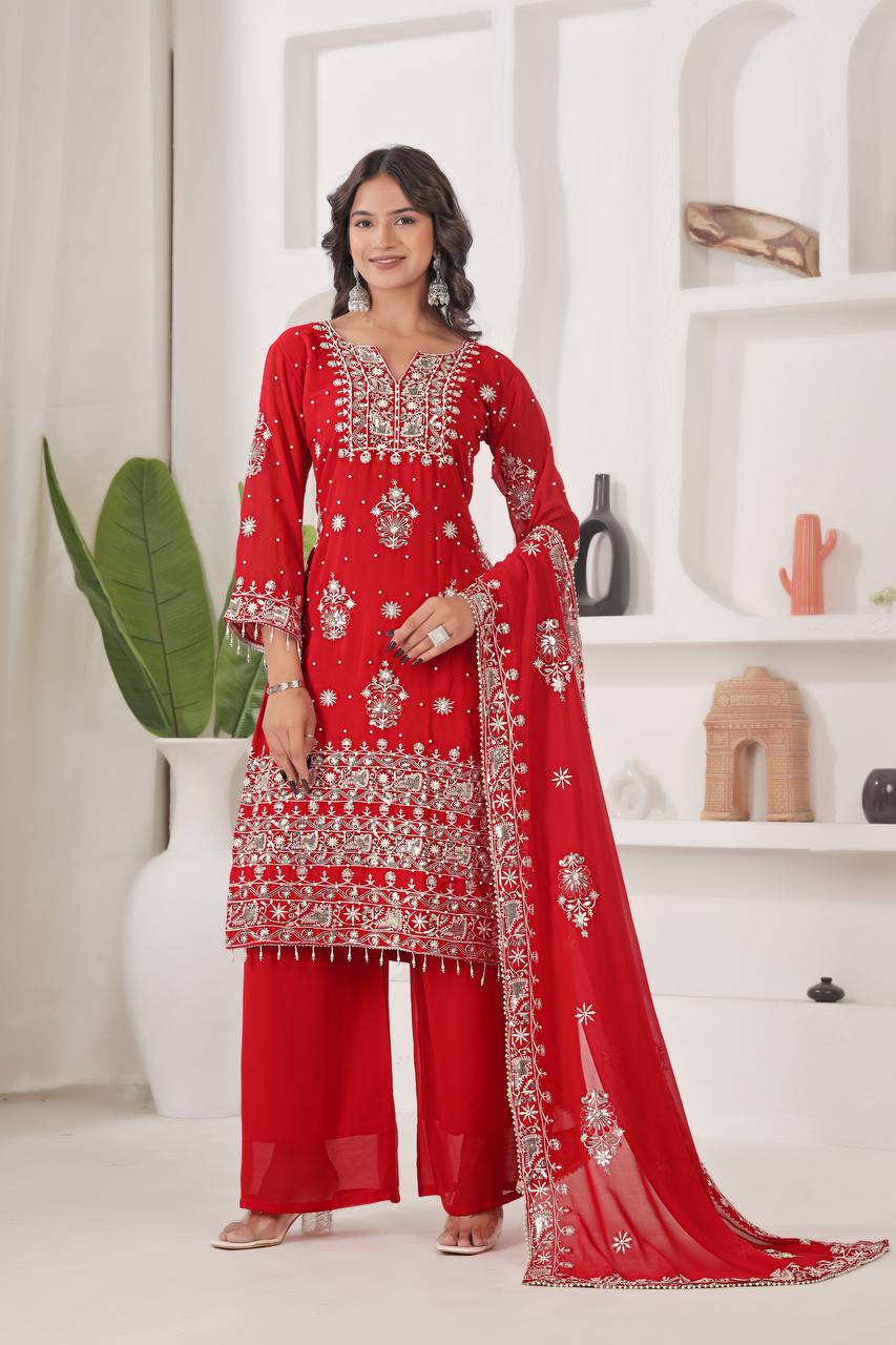 Woman wearing a fiery red georgette kurta set with heavy silver mirror work, sequins, and zari embroidery on the straight-cut kurta, broad palazzo pants, and matching dupatta.
