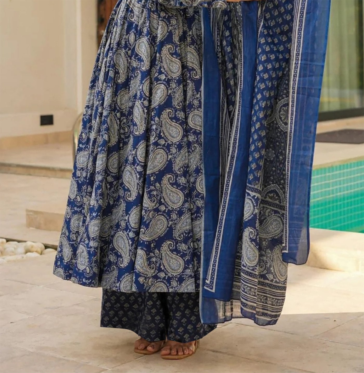 Full length view of a flared cotton anarkali with blue traditional prints and matching palazzo pants.