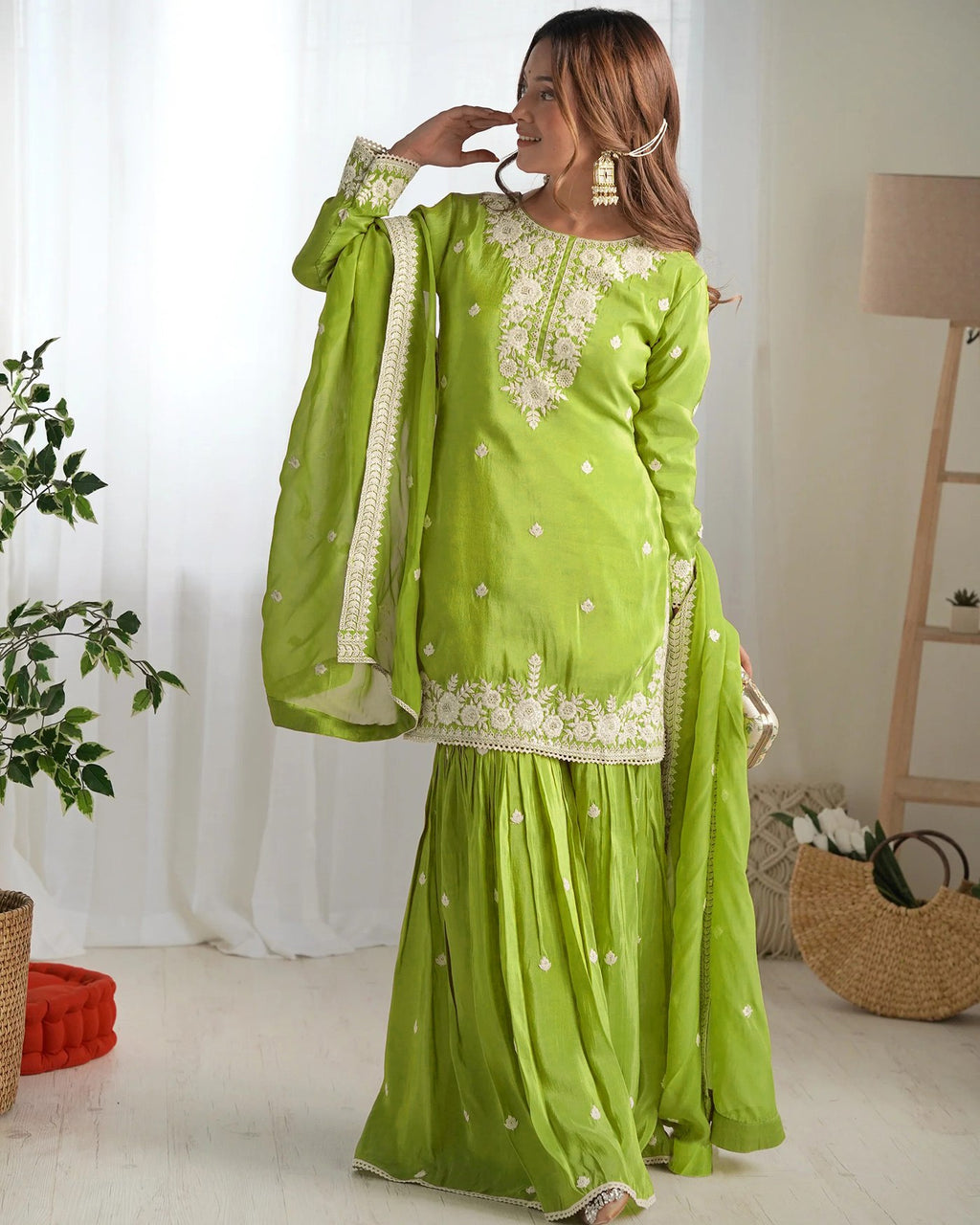 Woman wearing a vibrant lime green silk blend sharara suit with intricate white thread embroidery on the kurta, sleeves, and flared sharara.