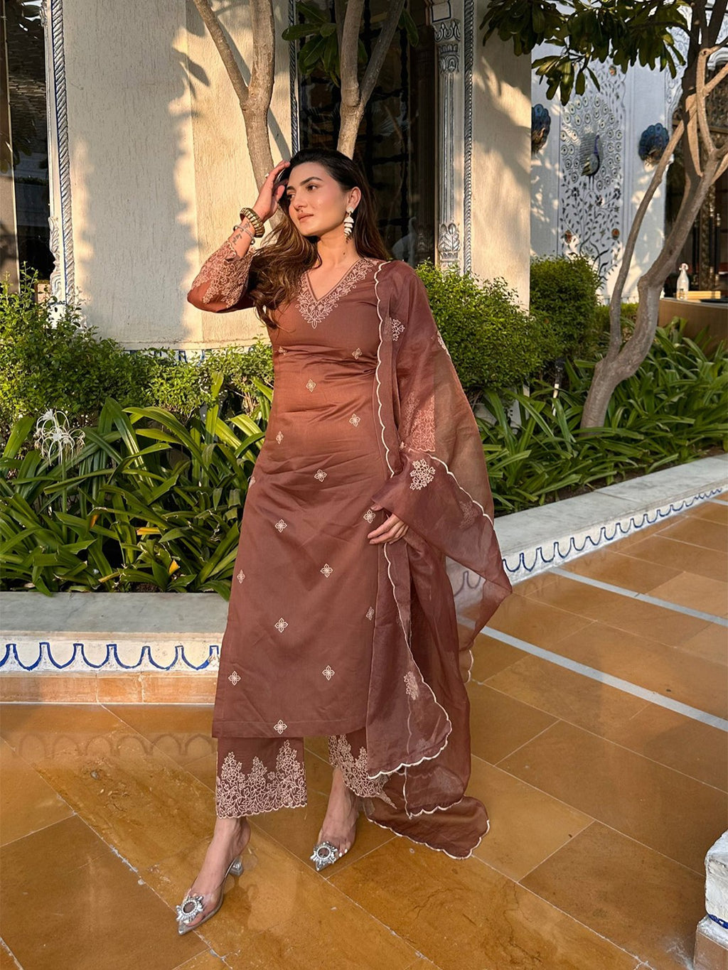 Luxury brown Punjabi suit with zari embroidery on neckline and flared sleeves, paired with straight pants and a sheer dupatta.