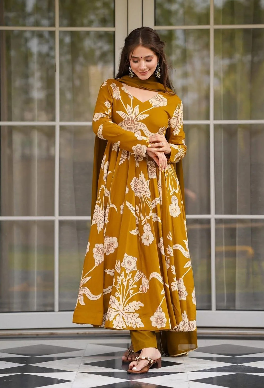 oman wearing a mustard yellow floral printed anarkali kurta set with full sleeves, matching pants, and dupatta.
