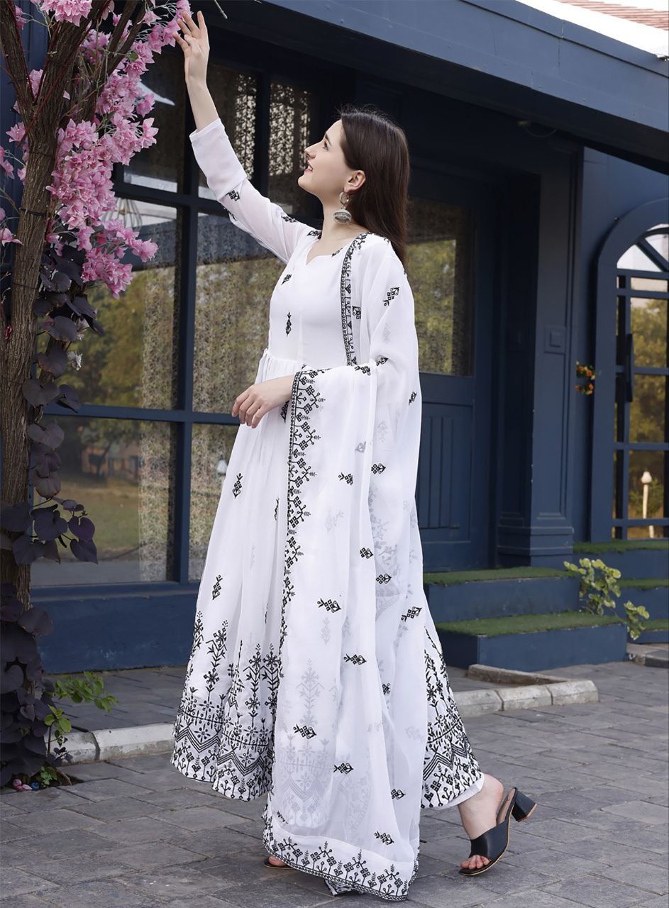 Model posing in a chic party wear white anarkali gown with contrast black embroidery/print, suitable for evening events.