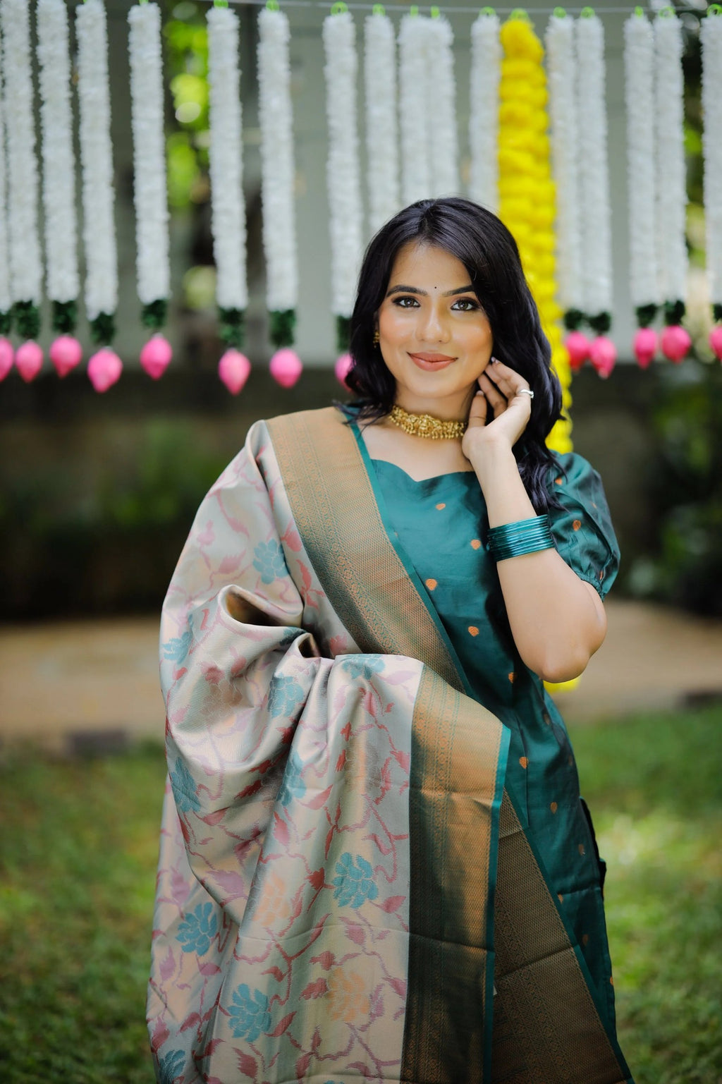 Woman wearing a puff sleeve green kurta with palazzo, accessorized with a gold choker and a Banarasi dupatta.