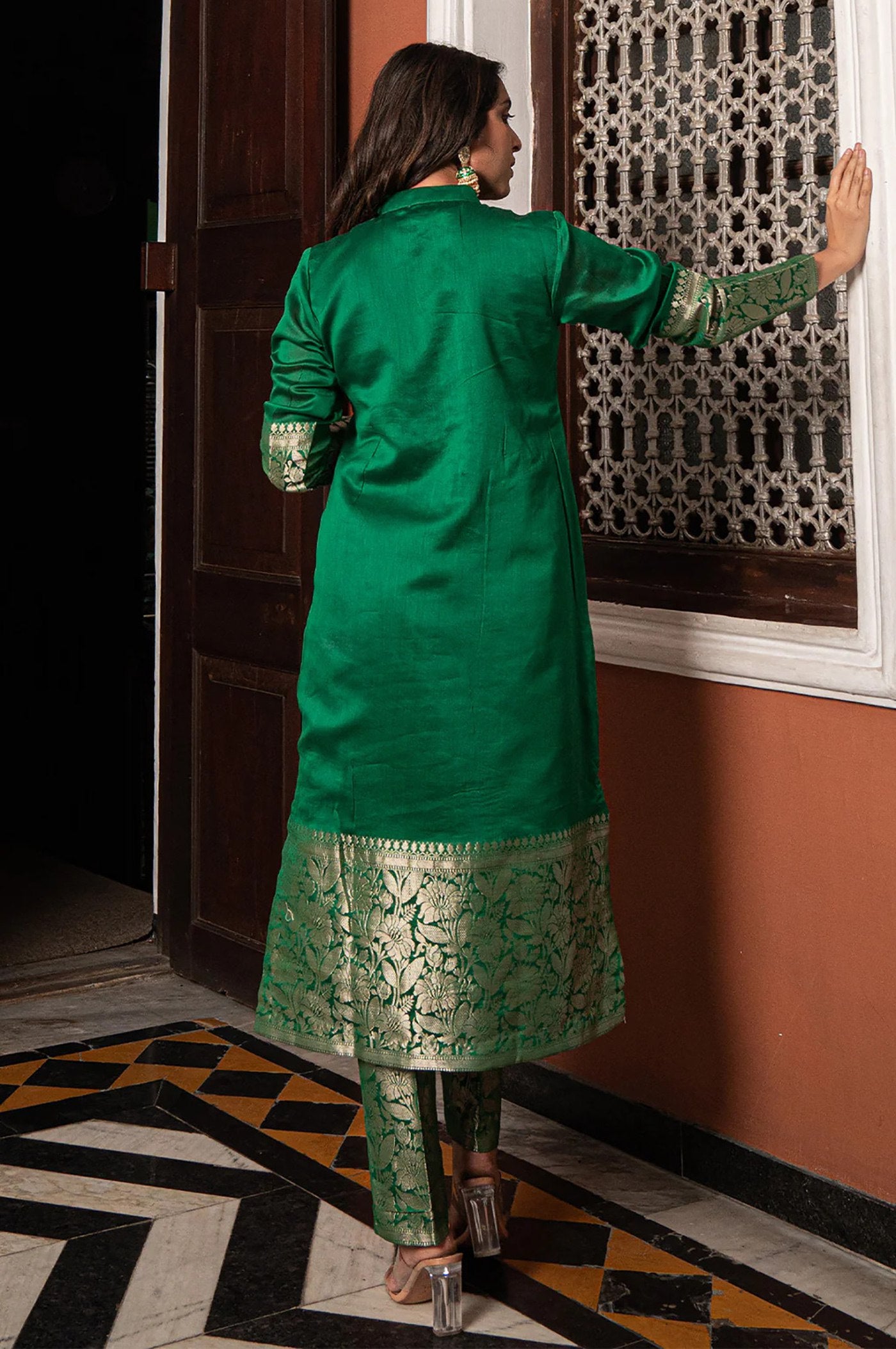 Traditional green brocade suit with straight kurta and pants, showcasing intricate gold weaving at the cuffs and hem.