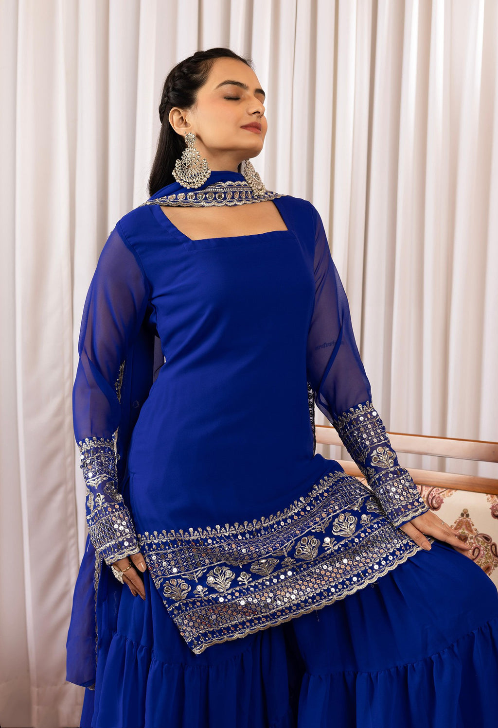 Model in a wedding and festive royal blue sharara suit, showcasing a tiered design and dazzling silver mirror work.