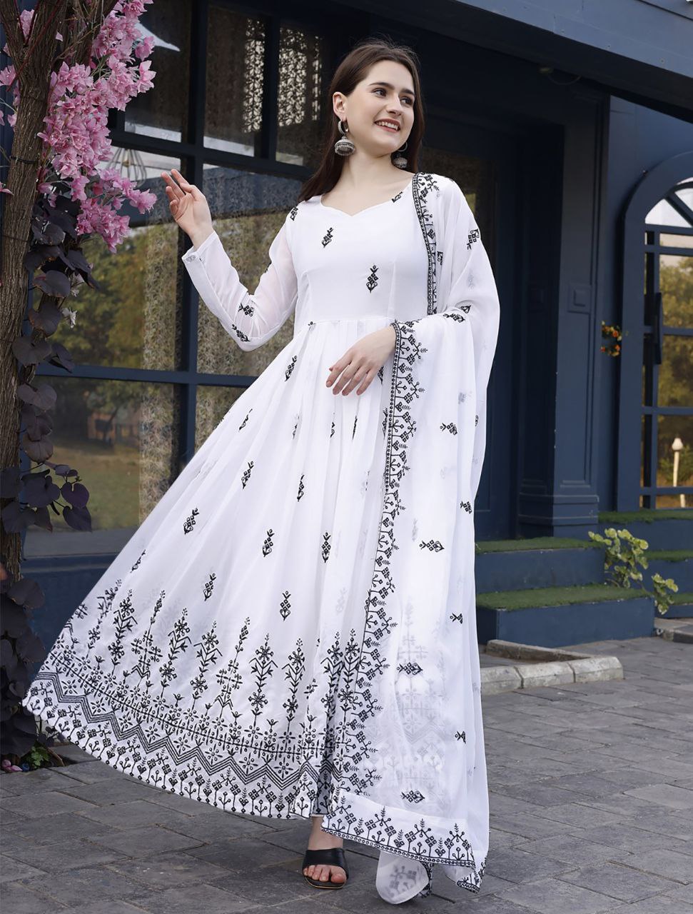 Woman wearing a flowing white georgette anarkali suit with intricate black thread work on the hem and sleeves, paired with a matching dupatta