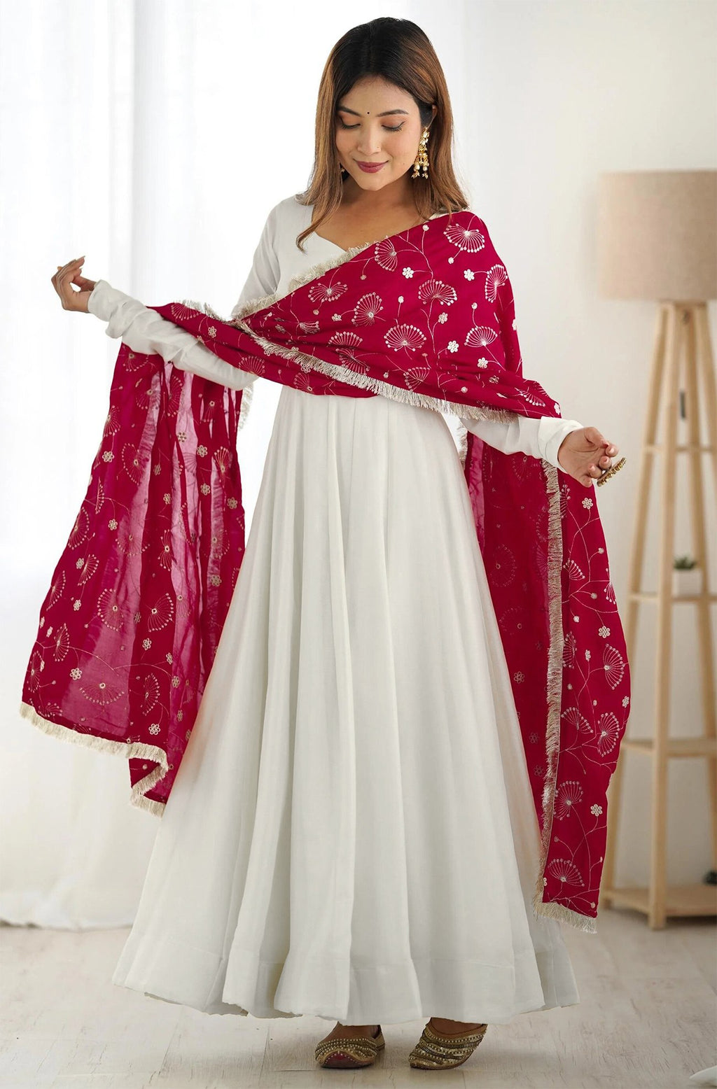 Woman wearing a plain white georgette flared anarkali gown with long sleeves, paired with a vibrant fuchsia (rani pink) dupatta featuring delicate gold foil print and fringe border.